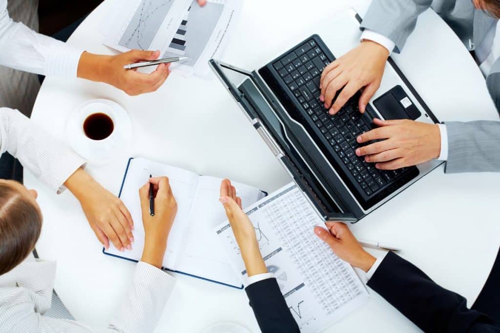 Un gruppo di uomini d'affari aziendali che lavorano su un laptop.