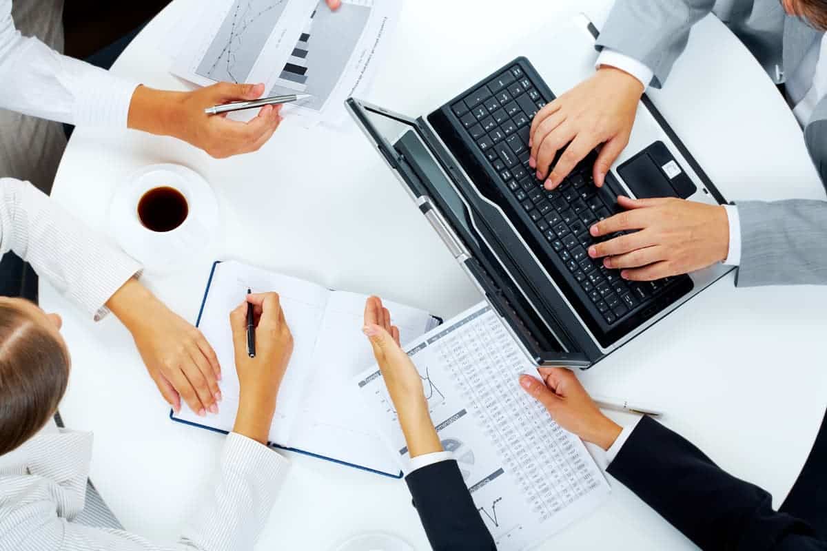 Un gruppo di uomini d'affari aziendali che lavorano su un laptop.