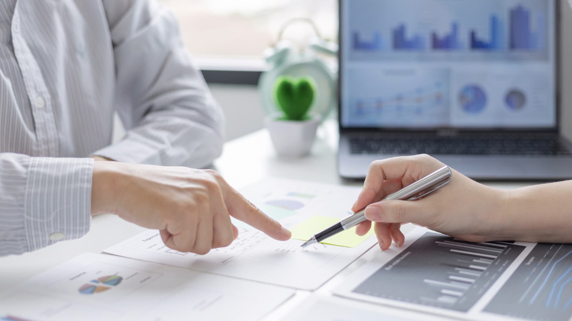 Incontro consultivo con due persone che analizzano documenti e grafici.